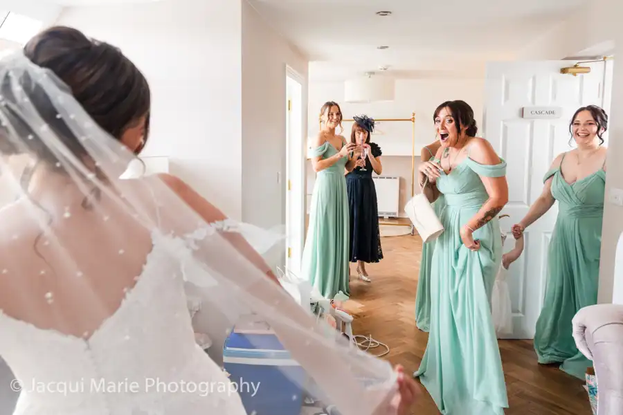 Wedding photograph of bridesmaids seeing the bride for the first time in her wedding dress by Hampshire Wedding Photographer Jacqui Marie Photography